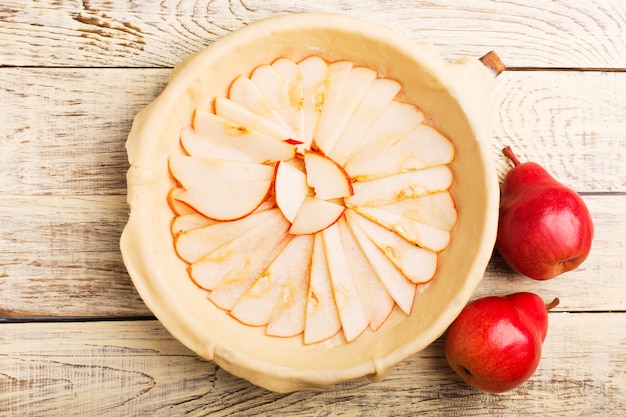 Préparation de la tarte aux poires sur une table en bois