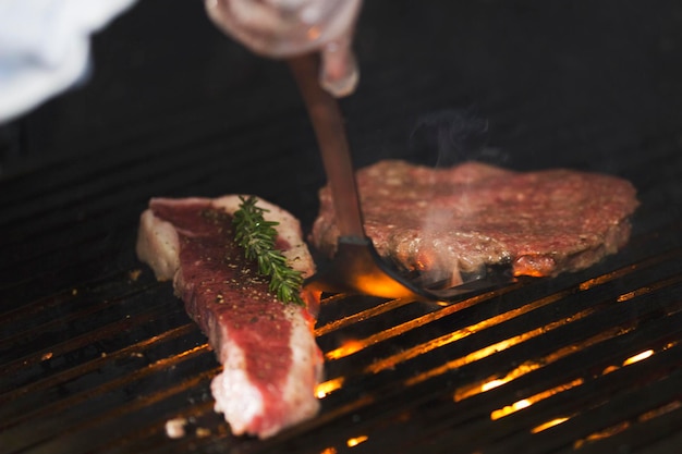 Préparation de la viande sur le grill, le chef retourne la pièce avec une pelle, concept de cuisine et haute cuisine