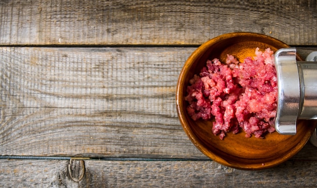 Préparé de viande. Cuisiner un hachoir à viande hachée. Sur une table en bois. Espace libre pour le texte. Vue de dessus