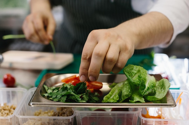 Préparer des légumes pour un délicieux plat de bol un chef masculin dans une cuisine de restaurant contemporaine