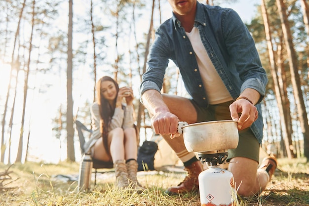 Préparer la nourriture Jeune couple voyage ensemble dans la forêt pendant la journée