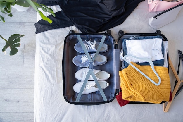 Préparer pour le voyage emballer la valise pour le voyage assis sur le lit à la maison