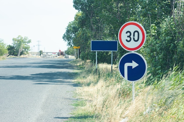 Photo près du panneau de limitation de vitesse et de la direction de la route