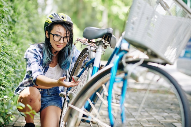 Photo près de pleurer jeune femme chinoise à la chaîne cassée de son vélo