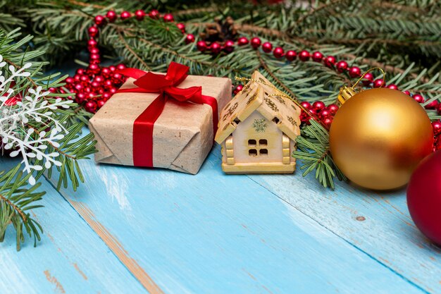 présent avec noeud rouge et décoration de Noël sur le fond en bois peint bleu