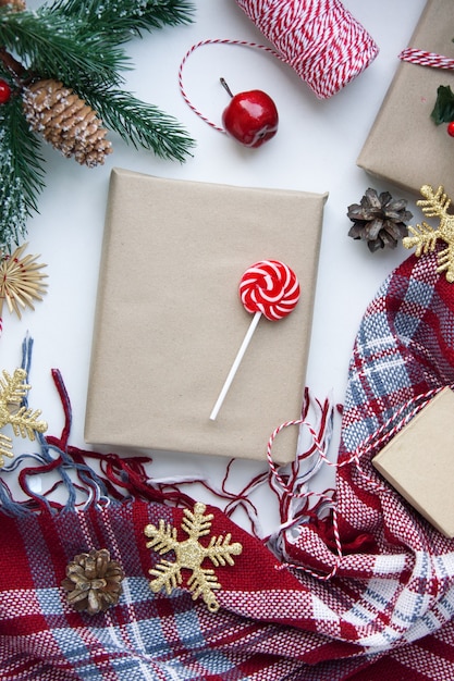 Présent en papier kraft brun, boîtes, bonbons, plaid et décoration de Noël sur table. Copiez l'espace. Concept de nouvel an écologique