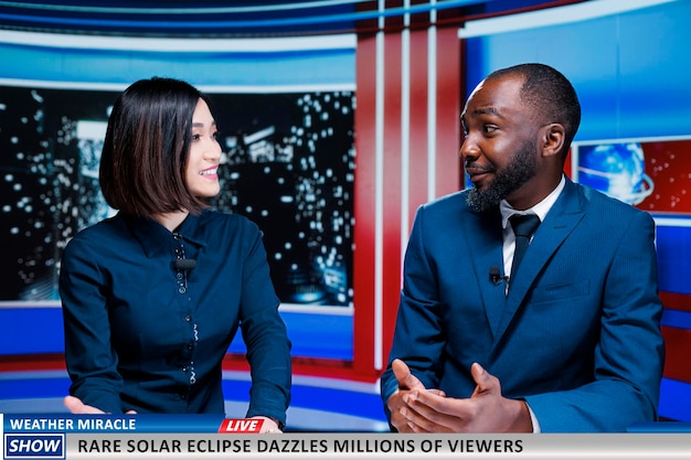 Les présentateurs parlent d'une éclipse solaire rare apparaissant dans le ciel divers présentateurs de nouvelles présentant un miracle météorologique et une belle lumière sur le soleil Une équipe de journalistes dans un spectacle nocturne discutant d'un événement naturel