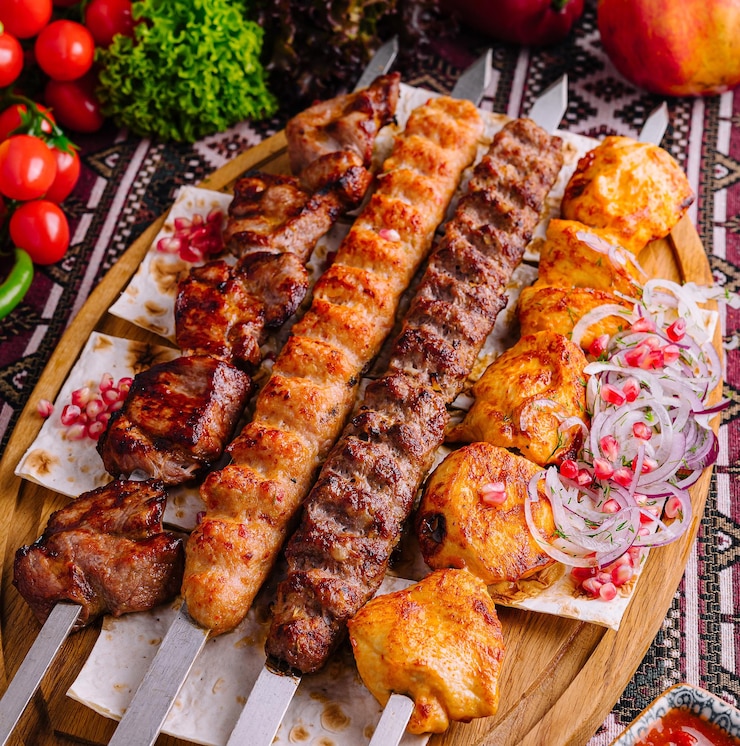 Photo présentation appétissante d'une variété de brochettes de barbecue grillées sur une planche de bois avec des légumes frais