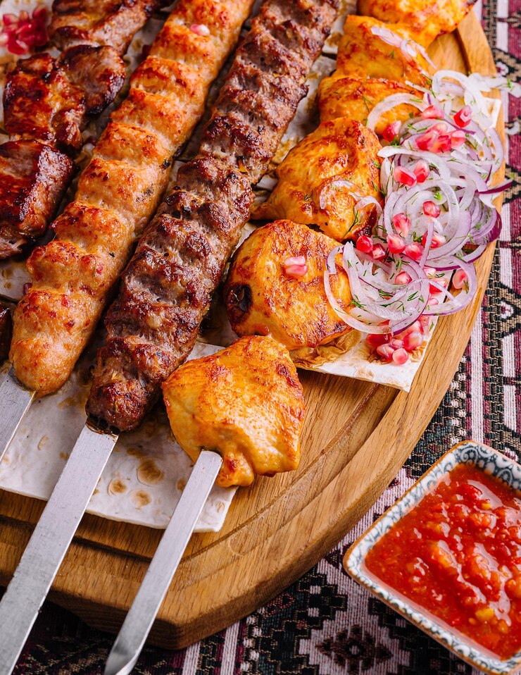 Photo présentation appétissante d'une variété de brochettes de barbecue grillées sur une planche de bois avec des légumes frais