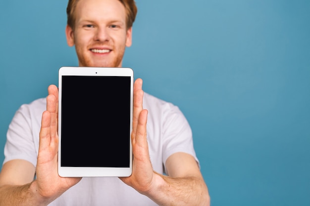 présentation du produit. promotion. jeune homme, tenue, dans, mains, tablette, informatique, à, écran blanc