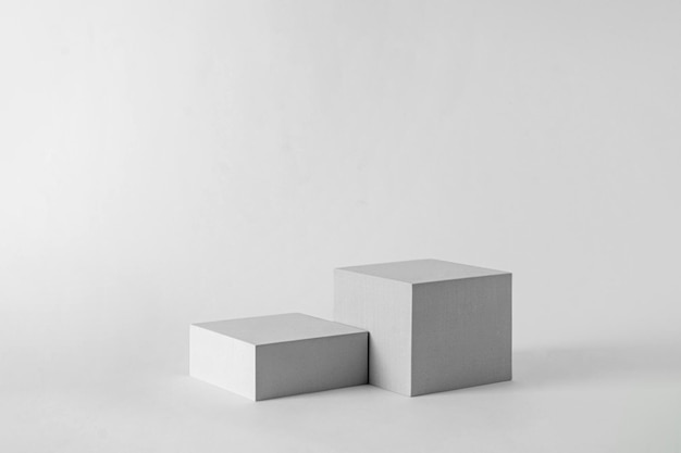 Présentation de maquette pour la plate-forme de cube géométrique de piédestal de podium de publicité de produit sur le fond gris et l'espace de copie