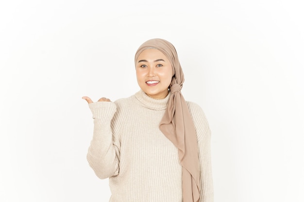 Présentation et pointage de côté avec le pouce Belle Asian Woman Wearing Hijab isolated On White