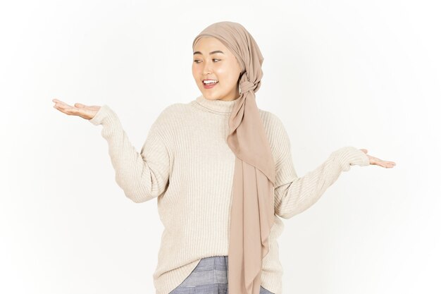 Présenter et montrer deux produits sur la paume de la belle femme asiatique portant le hijab