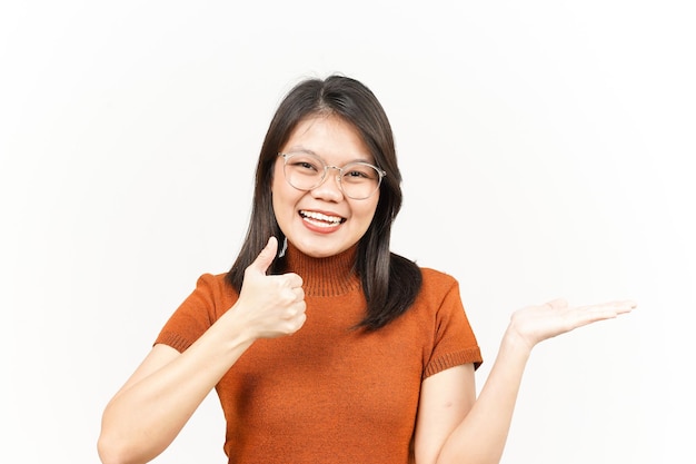 Présenter et montrer le produit sur la paume ouverte avec les pouces vers le haut d'une belle femme asiatique