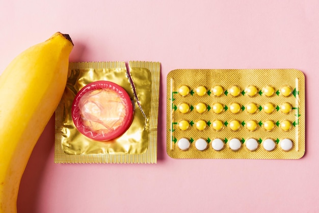 Préservatif sur emballage banane et pilule contraceptive