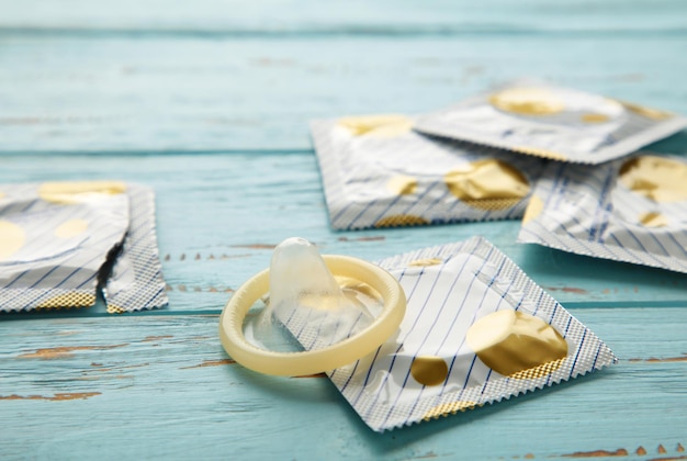 Préservatif ouvert et préservatif en pack sur fond bleu Utilisation d'un préservatif pour réduire la probabilité de grossesse ou de maladie sexuellement transmissible