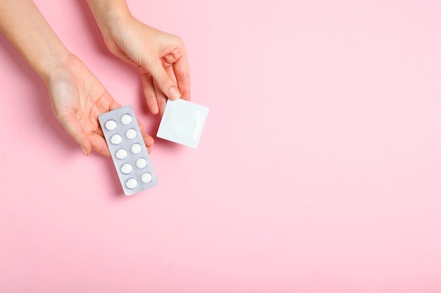 Préservatifs et autres contraceptifs sur un fond coloré