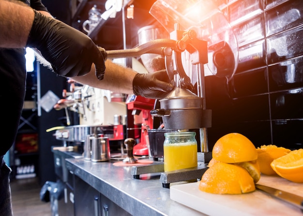 Presse-agrumes manuel en métal. Préparation de jus d'orange fraîchement pressé