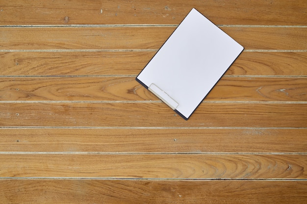 Presse-papiers avec une feuille blanche sur fond en bois