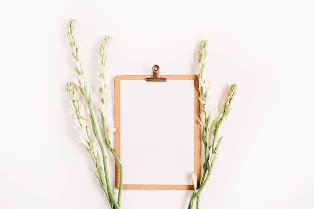 Presse-papiers et fleurs blanches à plat