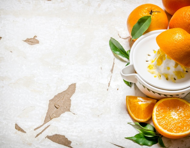 Presser le jus d'oranges fraîches sur table rustique.