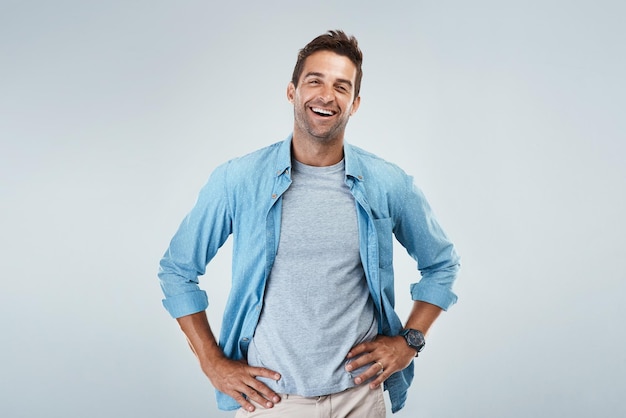 Prêt à affronter la journée Portrait d'un jeune homme joyeux souriant brillamment en se tenant debout sur un fond gris