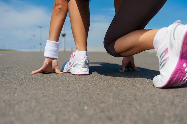 Prêt à courir. Image en gros plan d'une femme en chaussures de sport debout sur la ligne de départ