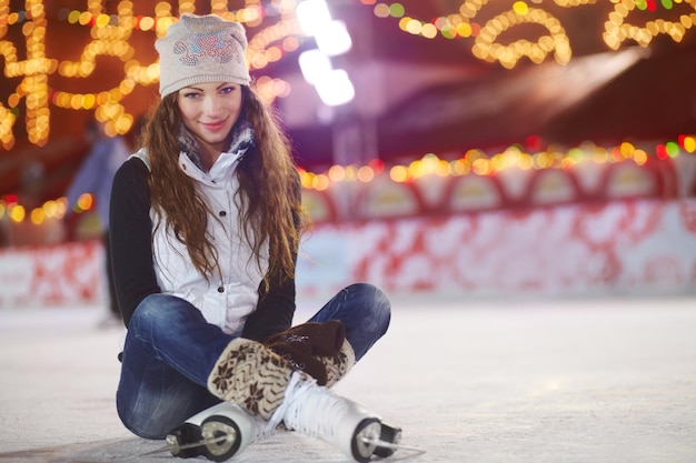 Prêt à découper de la glace Photo d'une femme assise assise sur une patinoire