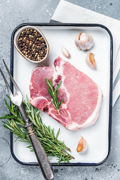 Prêt pour la cuisson Bifteck de viande hachée de porc cru aux herbes et épices Fond gris Vue de dessus