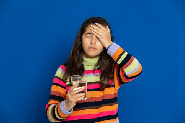 Preteen girl with striped jersey gesticulant sur mur bleu