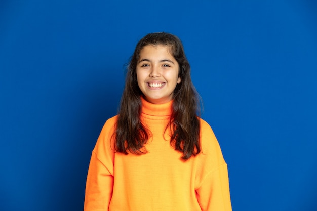 Preteen girl with yellow jersey gesticulant sur mur bleu