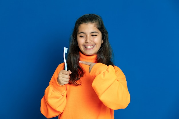 Preteen girl with yellow jersey gesticulant sur mur bleu