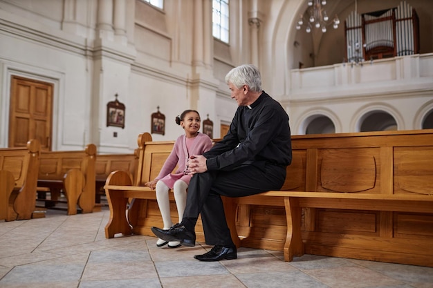 Prêtre parlant à une petite fille à l'église