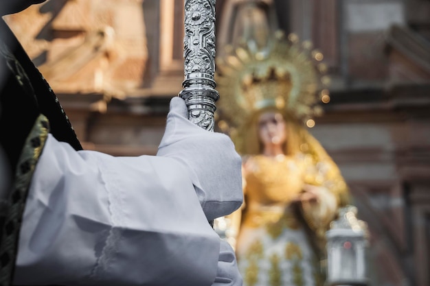 Photo un prêtre vêtu d'une robe blanche tient une statue de femme en robe blanche