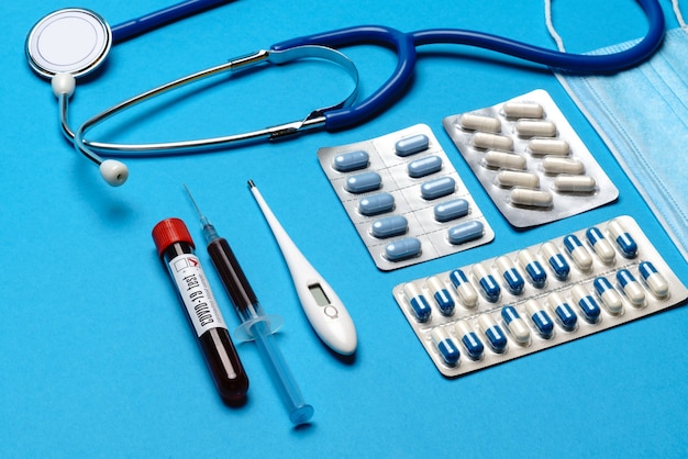 prévention et traitement du concept de soins de santé coronavirus - seringue, masque, comprimés, stéthoscope et