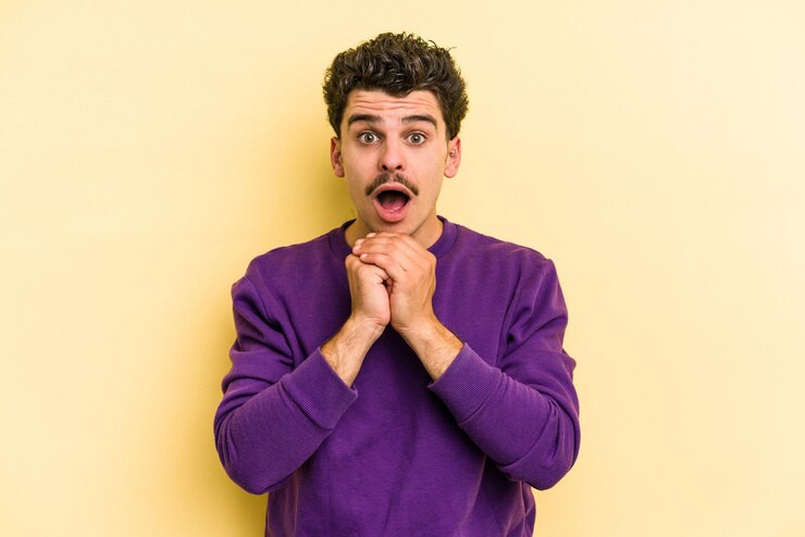 Photo prier pour la chance étonné et ouvrir la bouche en regardant vers l'avant