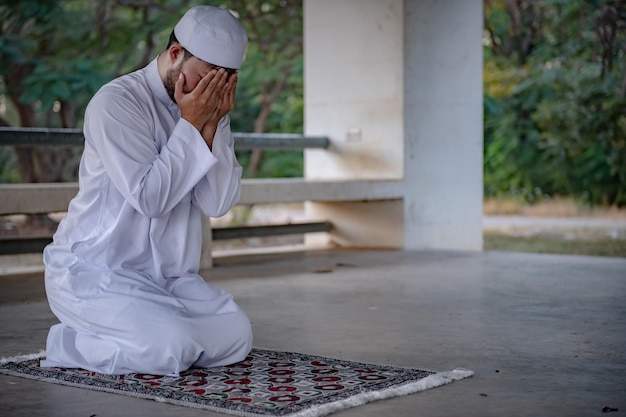 Prière de l'homme de l'islam asiatiqueJeune musulman priantConcept du festival du Ramadan