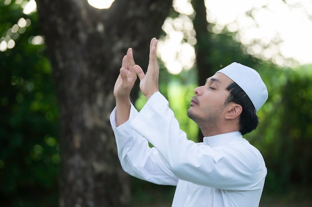 Prière de l'homme de l'islam asiatiqueJeune musulman priantConcept du festival du Ramadan