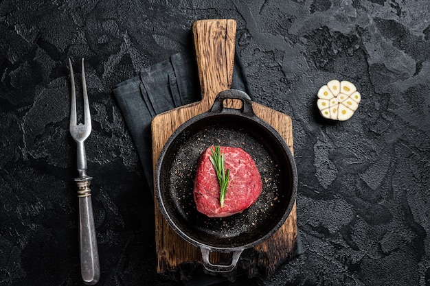 Prime Filet Mignon Steak de bœuf prêt pour la cuisson Viande de filet cru vieilli à sec Fond noir Vue de dessus