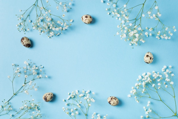 Printemps bleu fleurs cadre de Pâques avec des oeufs