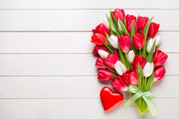 Le printemps. Bouquet de tulipes rouges sur fond en bois blanc.