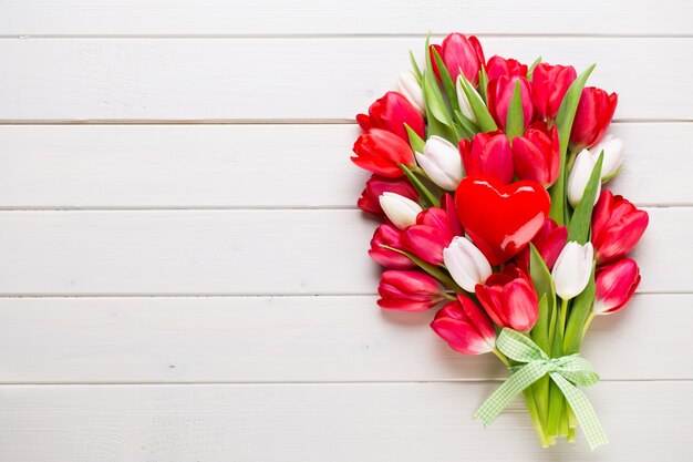 Le printemps. Bouquet de tulipes rouges sur fond en bois blanc.