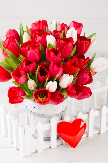 Le printemps. Bouquet de tulipes rouges sur fond en bois blanc.