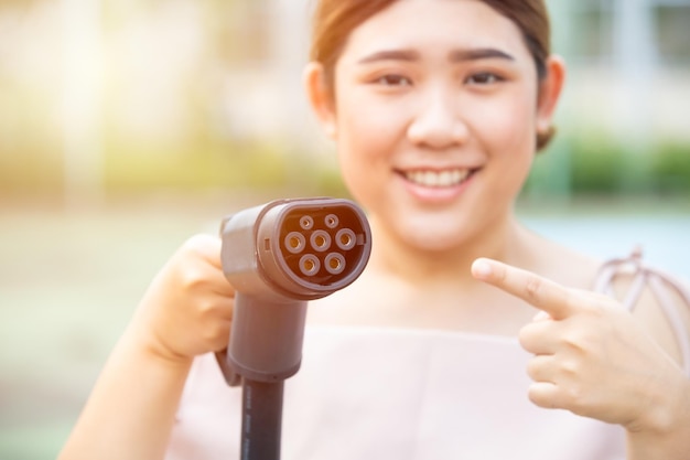 Prise de chargeur de voiture EU Type 2 EV avec des femmes souriantes heureuses pour un concept facile à charger et compatible