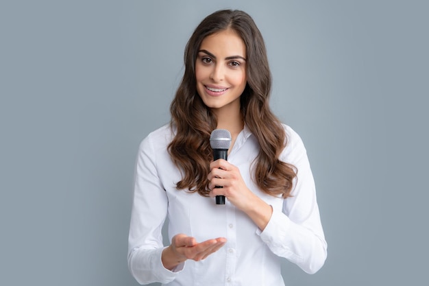 Prise de parole en public avec concept de présentation de discours de haut-parleur microphone Belle femme élégante chantant karaoké isolé sur fond gris
