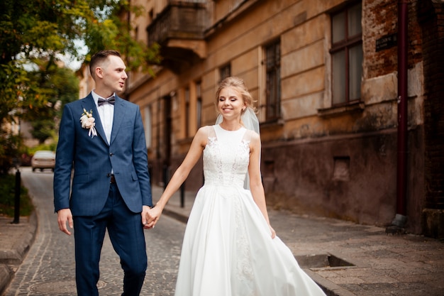 Prise de photos de mariage. Jeunes mariés marchant dans la ville