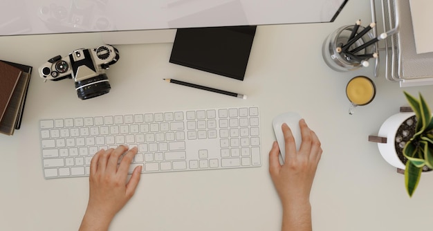 Prise de vue aérienne Une femme tapant sur un clavier d'ordinateur sur un espace de travail de bureau moderne