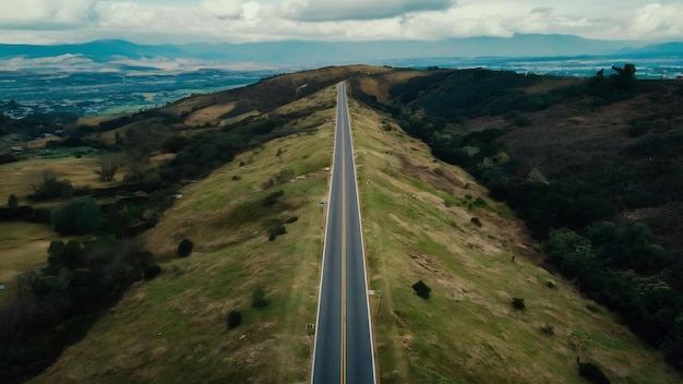 Une prise de vue aérienne d'une longue route sur la colline entourée de verdure et d'arbres