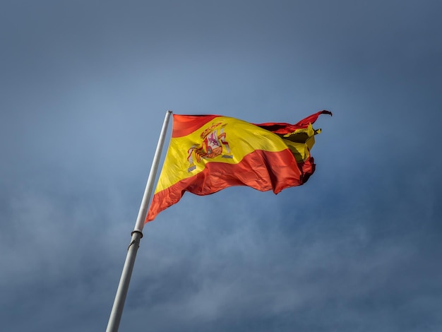 Prise de vue en angle bas d'un drapeau espagnol agitant sur le fond du ciel