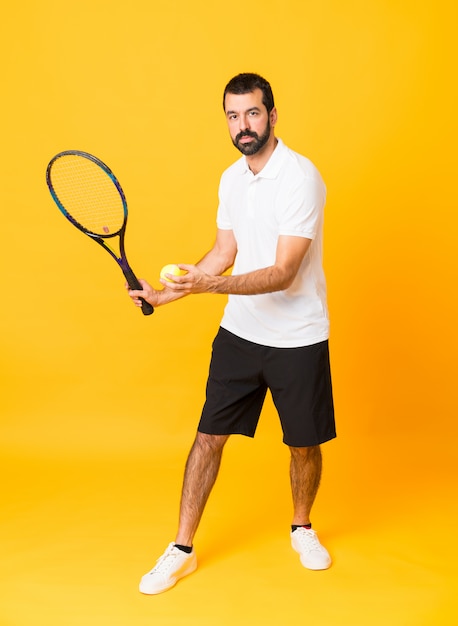 Prise de vue complète de l'homme au jaune isolé jouant au tennis